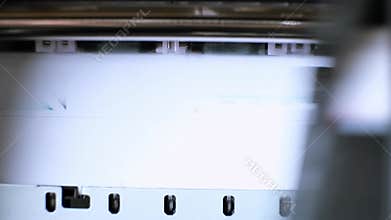Printing process of color inkjet printer close-up. The rolles is rolling inside of device and printed a picture. A color