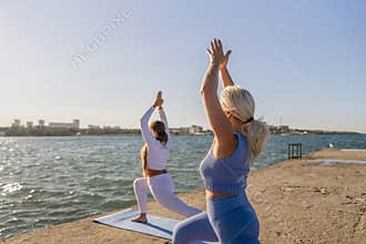 Yoga, Beach, Women practicing yoga poses on a beach at sunset.