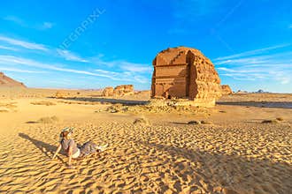 Tourist relaxing in front of Qasr Al Farid, the tomb of Lihyan son of Kuza in Al Ula, Saudi Arabia
