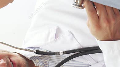 Doctor examines young girl’s lungs with a stethoscope and gives a thumbs up