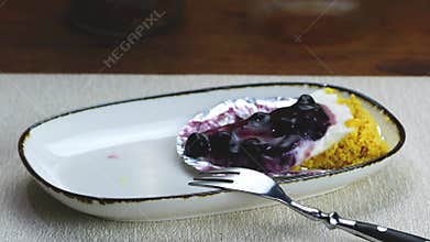 An old man drinking black coffee with blueberry cheese pie.