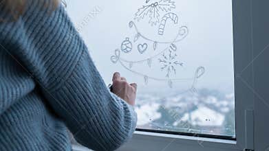 Stop motion video animation Sustainable responsible holiday decor. Female hand painting Christmas tree painted on window