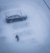 Woman walks during heavy snowfall, Season