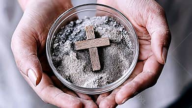 Hands holding ashes with wooden cross. Ash Wednesday