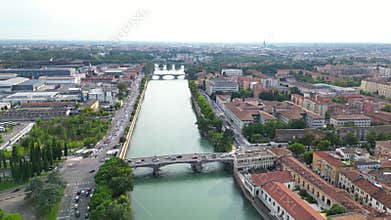 Drone view of bridges over Adige River along the city of Verona on a sunny day with misty sky
