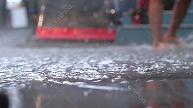 Rainwater collects on street as person walks through puddles