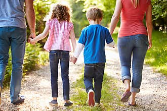 Rear View Of Family Walking In Countryside