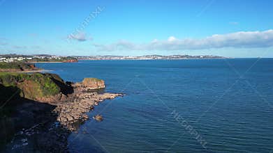 Broadsands, Torbay, South Devon, England: DRONE VIEWS: A reveal shot, over red sandstone cliffs, of the sea of Torbay
