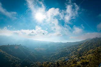 Sunlit Tropical Hills Beneath Bright Morning Clouds
