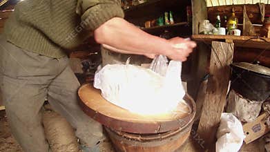 Farmer hands packs hot cheese in cheesecloth for dehydration shepherds cottage