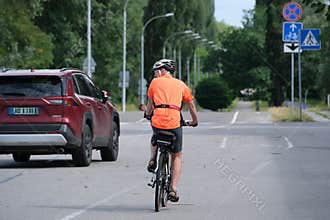 Cyclist Riding Along Urban Street With Bicycle Infrastructure