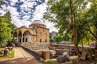 BULGARIA: Historic stone Orthodox church in green garden park setting