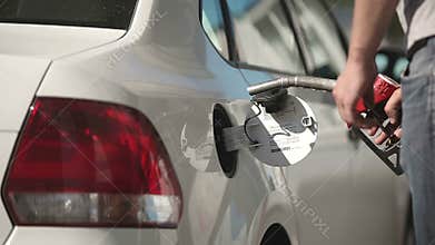 The driver pumping gasoline at the gas station.