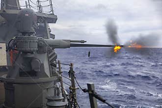 .U.S. Navy Arleigh Burke-class guided-missile destroyer USS Benfold (DDG 65) fires its Mark 38 Mod II 25-mm machine gun