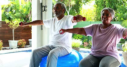 Senior couple exercising with dumbbell at home