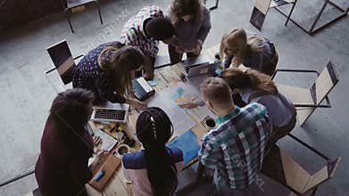 Brainstorming if creative mixed race group of people at modern office. Top view of group of people standing near table.