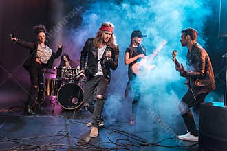 Singer with rock and roll band performing music on stage