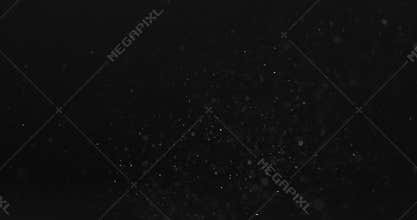 Dust particles fast moving over black background from right