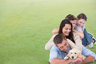 Happy family with dog lying on grass