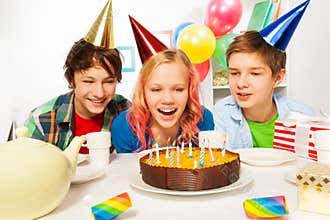 Happy teens celebrate birthday girl blow candles