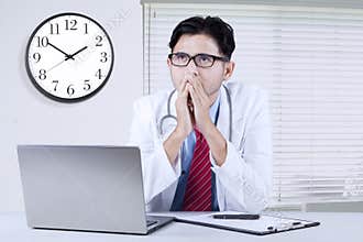 Pensive male doctor sitting in the clinic