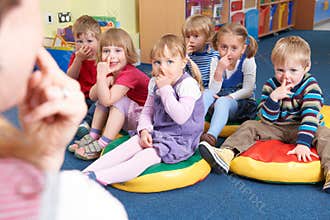Group Of Children Copying Teacher In Montessori/Pre-School Class