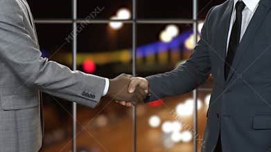 Businessman shakes black man's hand.