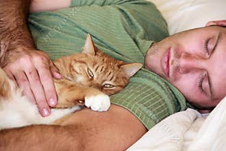 Cat and man laying on a bed