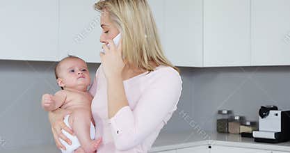 Mother calling while carrying her baby