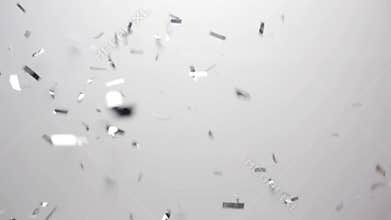 Silver confetti falling over white background