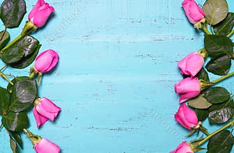 Vintage aqua blue wood background with pink rose buds.