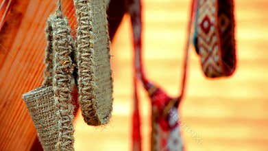 Wicker vintage bast shoes hanging on street. Slavic old bast shoes