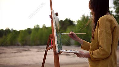 Plein air painting. Young artist working on easel outdoor