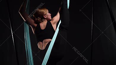 Yoga coach makes a vertical twine standing in a hammock