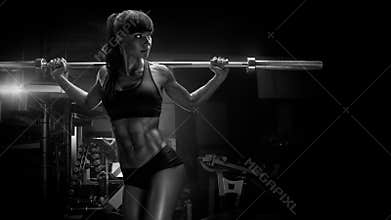 Black and white photo of fit young woman in great shape lifting