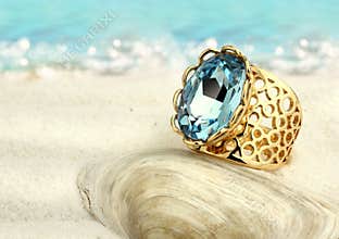 Jewellry ring with aquamarine on summer sand beach