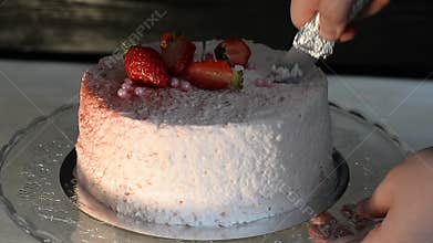 The pastry chef cut the cake. Strawberry yogurt cake. Consists of butter sponge cakes, covered with cream-based live
