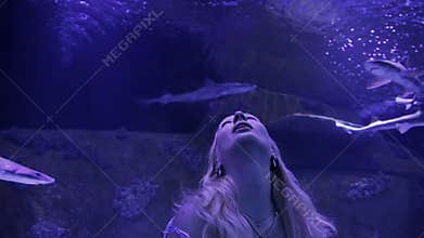 Woman enjoying aquarium view.