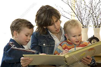 Mother and two son's reading a book