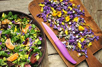Alkaline, healthy food: salad with flowers, fruit and valerian salad