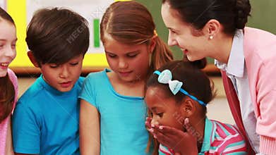 Teacher and pupils looking at laptop