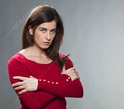 Suspecting 30s woman standing with arms crossed