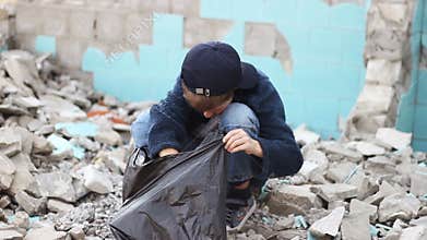 Homeless orphan boy looking for food in the