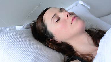 Young woman alone in bed waking up happy in bed