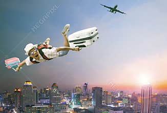 Younger man flying mid air with belonging luggage and passenger
