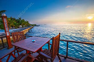 Beautiful sunset from restaurant on the beach. Tropical island w