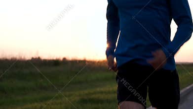 The athlete's body of a runner close-up while Jogging