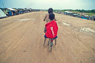 Poor cambodian kids racing with old bicycle