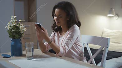 Young woman using mobile phone at home.