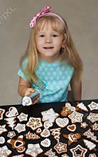 Little child decorating cookies with icing